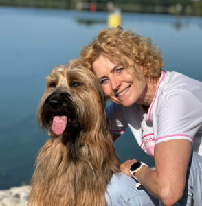 Frau und Hund sind in einem innigen, körperlich nahem Moment am Wasser - Antje Timmermann - Mind & Lead