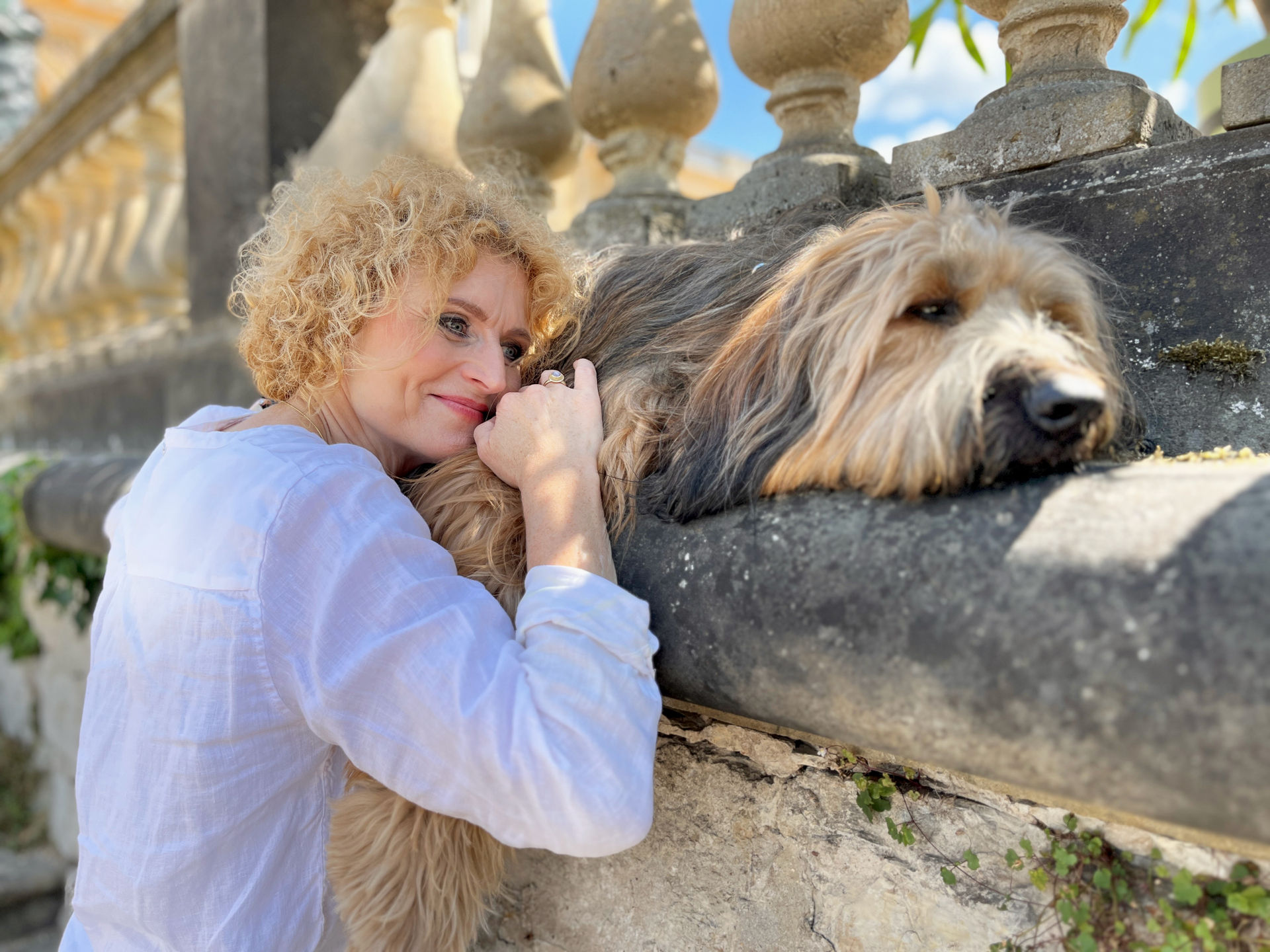 Selbstlernkurse-Frau schmiegt sich an ihren liegenden Hund an