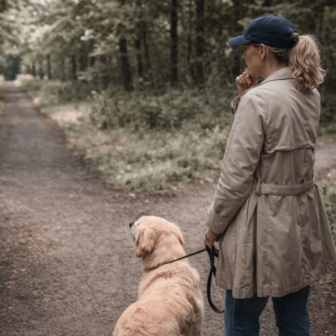 Frau mit Hund geht spazieren und ist sichtlich angespannt. Sie überlegt, welchen Weg sie gehen kann, um auf niemanden zu treffen